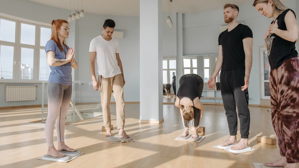Participants in a yoga class practice meditation and relaxation on sadhu boards.