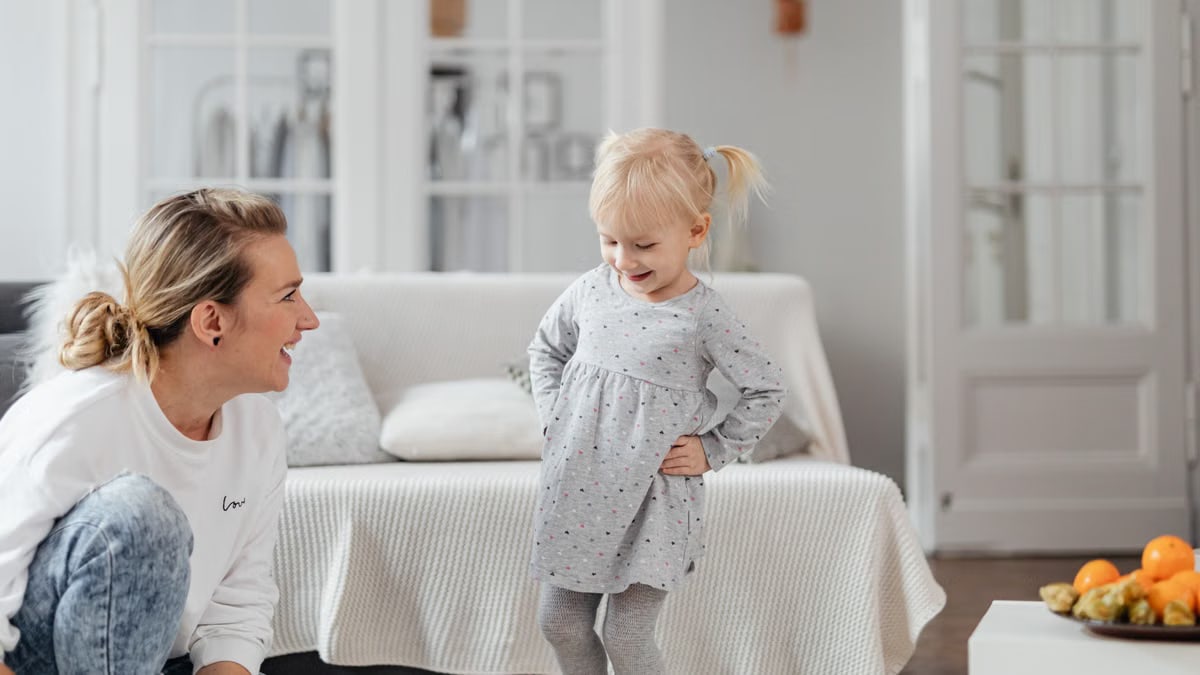 A mother and daughter sharing a joyful moment together in a cozy living room setting.